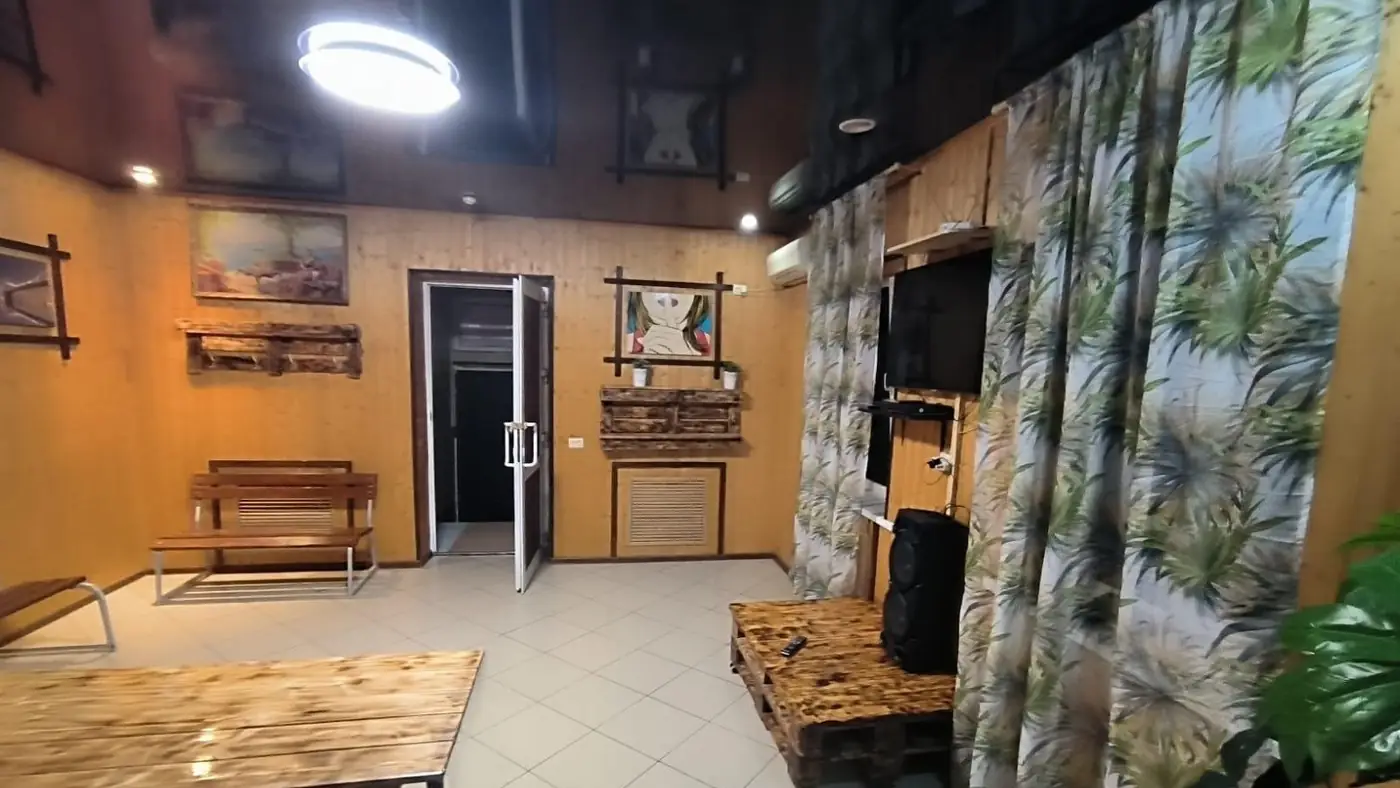 Зона отдыха бани с деревянной отделкой и телевизором